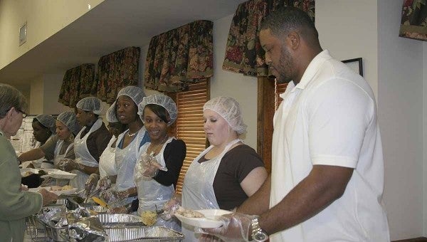 Cornelius Griffin serves meals to area residents Tuesday alongside family and friends at the annual Thanksgiving dinner he hosts as a way to give back to the community that supported him as a child and during his NFL days.
