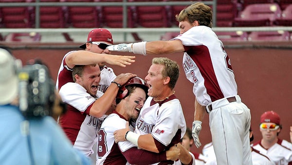 Troy players celebrate with Josh McDorman (38) after McDorman was walked in for the winning run of an NCAA college baseball game against Alabama in Tallahassee, Fla., Sunday, June 2, 2013. Troy won 9-8. (Photo/Thomas Graning)