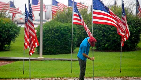 Cortland Peed replaces a flag that had fallen due to winds at Bicentennial Park.