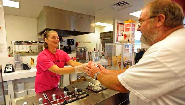 Stephanie Wasburn serves ice cream to Billy Williamson, of Brantley, Ala., at Milky Moo’s in Troy. 