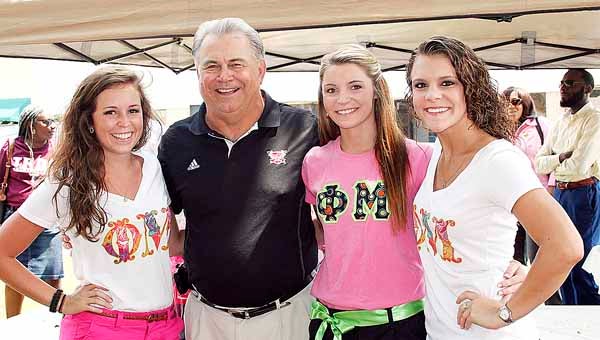 Troy University Head Football Coach Larry Blakeney took time to pose for photographs with members of Phi Mu Sorority who assisted with the Brown Bag on the Square event. Pictured with Blakeney are Kaitlyn Sexton, Catherine Trisch and Brooke Pilchar.