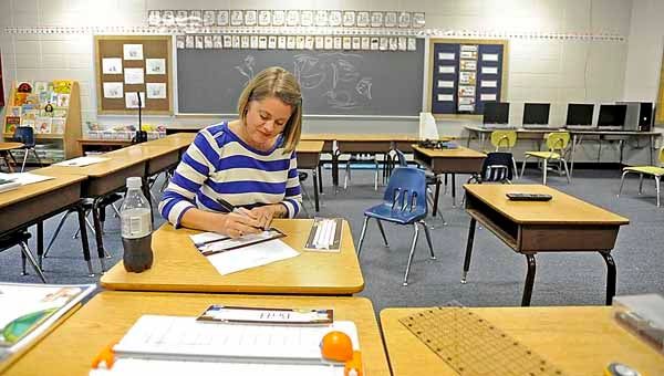 First-grade teacher Heather Bunn works on name tags for desks in her classroom on Friday. 