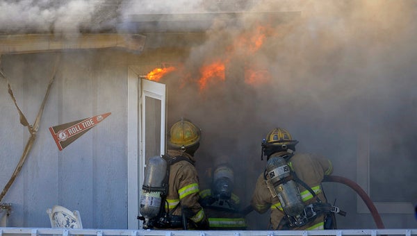 Troy firefighters work to extinguish a house fire on Warren Court in Troy, Ala., Tuesday, Dec. 24, 2013. (Photo/Thomas Graning)