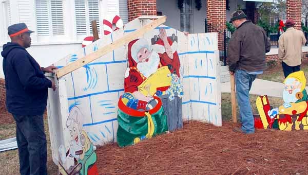 Photo by Jaine Treadwell | Brundidge city workers clean up and repair the Christmas display at the library Monday morning after an attack from vandals. 