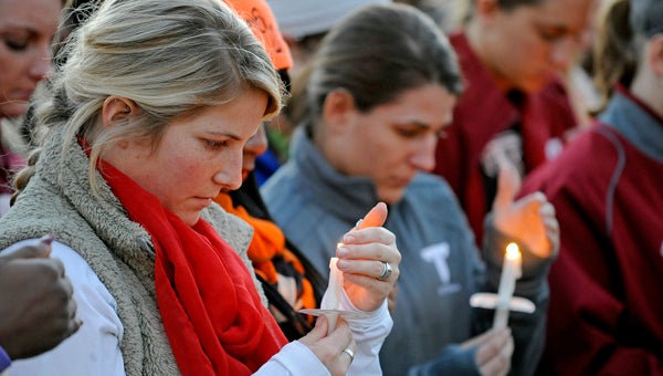Troy University students light candles during a candlelight vigil at the university in Troy, Ala., Wednesday, Jan. 15, 2014. Troy University students Haijiao Sun, Kimberle Johnson, Kristin Fuller and Jadarius Garner were killed in unrelated incidents over the school's Christmas break. (Photo/Thomas Graning)