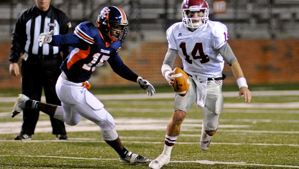 UMS-Wright quarterback Gunner Roach (14) attempts to out-run Charles Henderson's Richard McBryde (15) during the first half of an semi-final game of the AHSAA 4A playoffs in Troy, Ala., Friday, Nov. 29, 2013. (Photo/Thomas Graning)