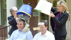 CFO of Troy Bank & Trust Jeff Bentley, left, and CEO and bank president Jeff Kervin, right, accepted their ALS Ice Bucket Challenge from Sisters’ Restaurant and Jim Jackson Wednesday afternoon, but the bank put their own twist on the challenge. Instead of dumping ice over their heads, the two had senior vice president Gayla Kenney, left, and the senior trust officer Tenise Owens, right, dump an $1,000 donation out of the buckets. Dianna Lee, the marketing and public relations officer for the bank, said it was a great way to encourage people to donate to the ALS foundation. Troy Bank & Trust did not challenge anyone, but instead Lee said the bank members encouraged others to go to ALSA.org and donate.  Messenger Photo/Scottie Brown
