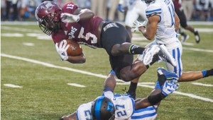 Troy University running back Khary Franklin dives over a Duke defender during Saturday’s game. While Coach Larry Blakeney said the Trojans played better than their season opener, the Trojans fell to the ACC Coastal champs 34-17. Below, Brandon Burks, a junior running back from Daleville, scrambles for yardage. MESSENGER PHOTO/JOEY MEREDITH
