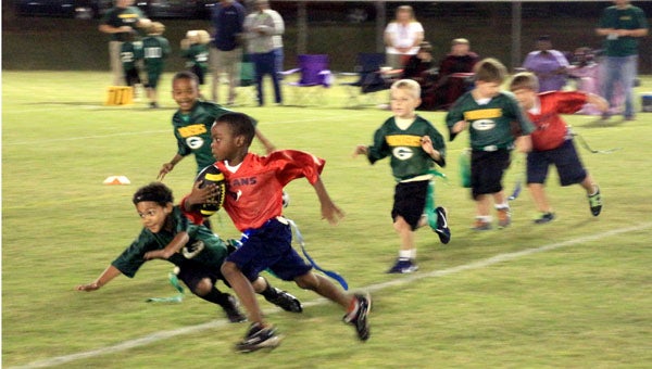 Above, T’quary Kelly runs the ball for the Texans Tues. night at their rec league flag football game against the Packers. The Packers won 29-5. (MESSENGER PHOTOS/APRIL GARON)