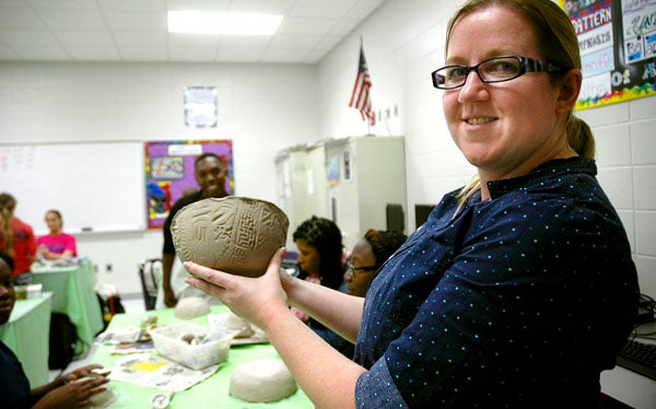 PCHS art teacher Carrie Rigdon shows off the handiwork of her students who are making bowls for the Salvation Army's annual Empty Bowls fund-raising event.
