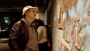 Robert Sanders admires one of the 11 works of art on exhibit during Thursday’s Senior Thesis art show in Malone Hall. MESSENGER PHOTO/SCOTTIE BROWN