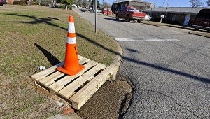 A wooden pallet and cone cover a storm drain on Brundidge Boulevard.  MESSENGER PHOTO/THOMAS GRANING