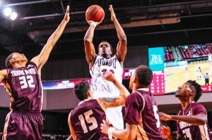 Troy University Athletics Aaron Ariri shoots over three Texas State defenders Tuesday night in the Trojans’ 57-46 loss. 
