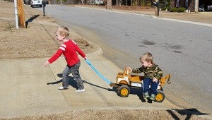 Trevor Mixon pulls his brother, Evan, in a wagon outside of their home on Feb. 7. MESSENGER PHOTO/COURTNEY PATTERSON