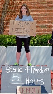 Angie Lewis, president of Troy Voice of Justice, stands for freedom during the fundraising event.