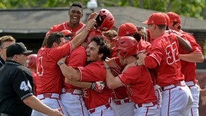 Louisiana Lafayette players swarm Stefan Trosclair, center wearing helmet, after Trosclair's grand slam during a Sun Belt Conference tournament championship NCAA college baseball game in Troy, Ala., Sunday, May 24, 2015. Louisiana Lafayette won 5-1 in 12 innings. (Photo/Thomas Graning)