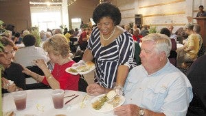 Messenger Photo/Jaine Treadwell Catherine Jordan, Colley Senior Complex director, played the role of server at the Older Americans luncheon hosted by the City of Troy Tuesday at The Studio. She served Stan Baxter while Clara Culpepper and Allene Snider waited “patiently.”