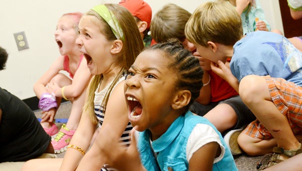 Messenger photo/Courtney Patterson First Baptist Church Troy continued its week of Camp Kilimanjaro Vacation Bible School Tuesday. Jacie Brown, front, and Sydney Boothe, back, open their mouths as wide as a hippo as they learn the importance of the words that come from their mouths.
