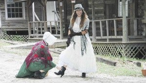 Messenger Photo/Jaine Treadwell  Sharon Brooks and Elizabeth DuMont leisurely strolled Pioneer Village during Log Cabin Days Friday until the laces of Brooks high-top shoe came untied. 
