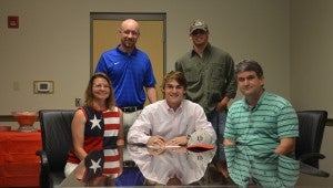 MESSENGER PHOTO/MIKE HENSLEY Reilly Fox, center, signed a scholarship to play baseball and attend Jefferson Davis Community College in the fall. Pictured are Sheree and Gary Fox, seated, and Fox's former head coach Derek Irons, standing at left.