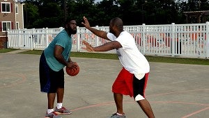 MESSENGER PHOTO/QUINTA GOINES Brothers Justin Flowers and Lindsay Marsh enjoy a Sunday evening game of basketball while using this weekend’s hot temperatures to their advantage to be active and shed some pounds.