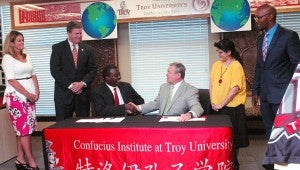 MESSENGER PHOTO/COURTNEY PATTERSON CHMS Principal Aaron Brown, center left, shakes hands with Service Vice Chancellor for Academic Affairs Earl Ingram, finalizing the partnership between Troy University and CHMS to bring a Confucius Institute classroom to the middle school. Pictured from left are CHMS Assistant Principal Lise Fayson, Troy City Schools Superintendent Dr. Lee Hicks, Brown, Ingram, Confucius Institute Director Iris Xu and Confucius Institute Administrative Support Specialist Charles Jones.