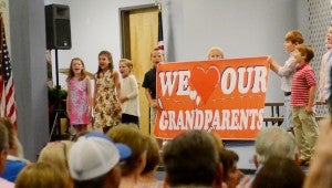 MESSENGER PHOTO/COURTNEY PATTERSON The third grade class at Pike Liberal Arts hold a sign saying “We Love Our Grandparents” during the Grandparents Day program Friday. X