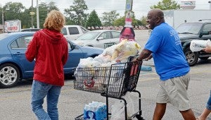 MESSENGER PHOTO/COURTNEY PATTERSON Members of The Vine Church assisted Food World customers with getting groceries to the car during their annual Serve Day.