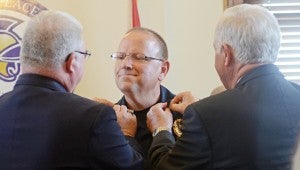 MESSENGER PHOTO/COURTNEY PATTERSON Police Chief Randall Barr, center, was pinned at the swearing-in ceremony by former police chiefs Jimmy Ennis, left, and Grady Reeves, right.