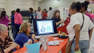 MESSENGER PHOTO/COURTNEY PATTERSON A parent receives free school supplies after visiting three showcases at the Pike County Schools 8th Annual Parent Expo Thursday night.