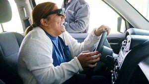 MESSENGER PHOTO/COURTNEY PATTERSON Troy University students experienced first hand the effects and consequences of driving drunk and texting and driving in a simulation car. Pictured, Shelby Morgan laughs at herself as she cannot stay on the road.