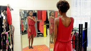 MESSENGER PHOTO/COURTNEY PATTERSON Charles Henderson Middle School students were able to shop in the Closet 2 Closet on-campus boutique for the first time Friday. Students earn points for good behavior and are able to use them to purchase clothing in the shop. Donations are always accepted at CHMS. Pictured, Rayvion Williams tries on a dress.