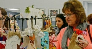 MESSENGER PHOTO/COURTNEY PATTERSON Linda Helms looks at the selections of wooden creations at one of the booths.