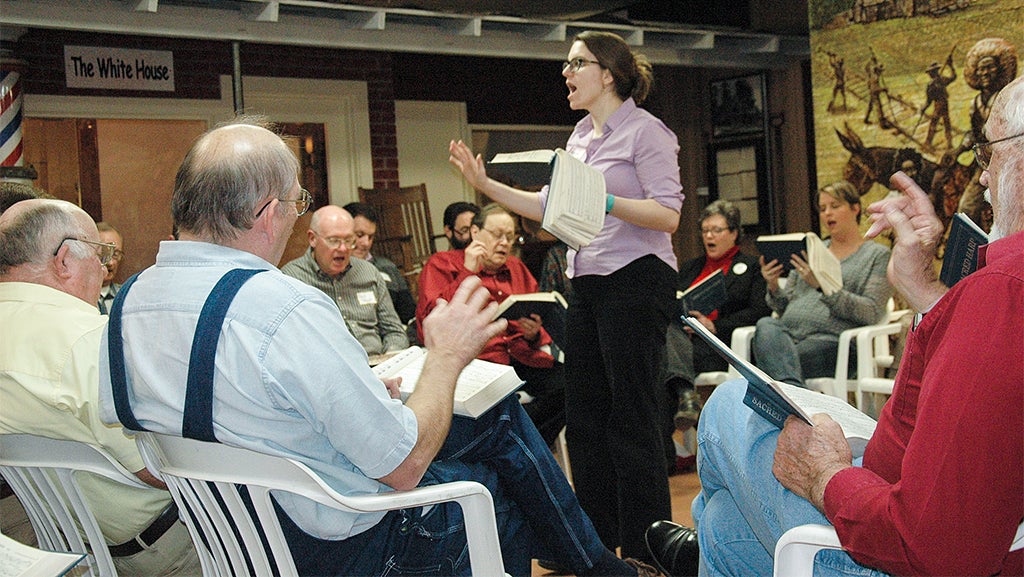 Dozens of participants joined together for the Sacred Harp singing at the Pioneer Museum last weekend. The event relies on shape-note signing, which uses only the vocal prowess of the participants to create the notes and, in turn, reveal the poetry of the music. Above, a song leader guides singers through the first songs. Below, Tim Cook and his wife Mako, who are originally from Michigan, said they have been inspired by the music in which the voices act as the harps. And, bottom right, Ewan Eddins was the youngest songleader at the singing.