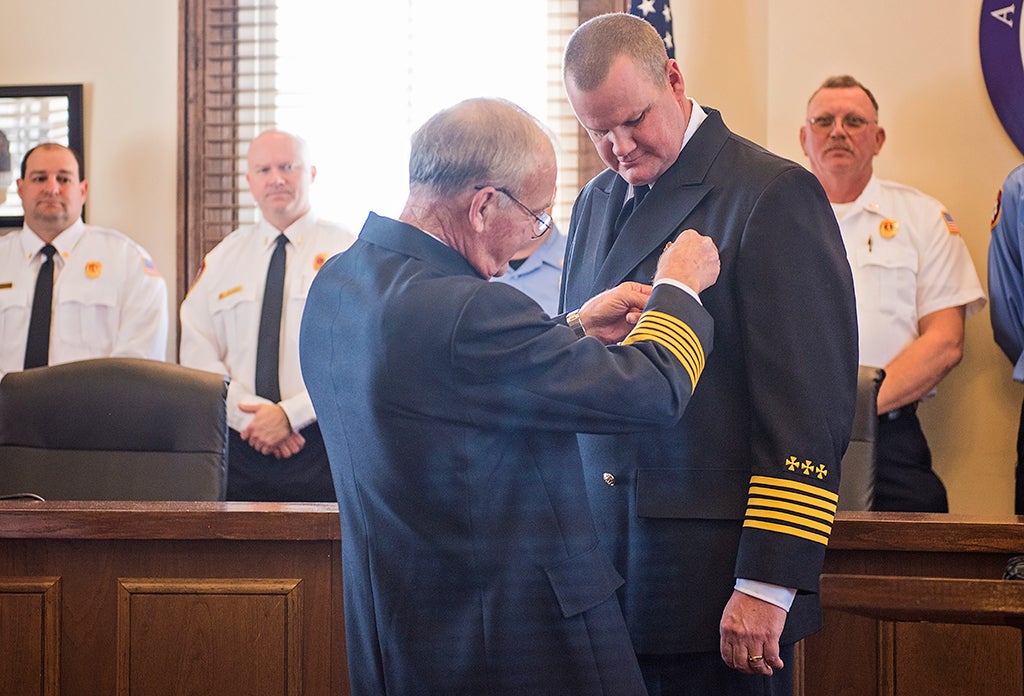 Photo courtesy Jonah Enfinger Retired Chief Thomas Outlaw pins incoming Fire Chief Michael "Buford" Stephens during the swearing-in ceremony on Tuesday.
