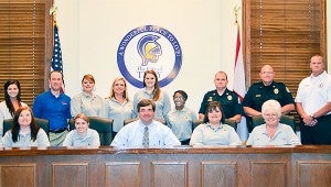 Troy Mayor Jason A. Reeves has signed a proclamation declaring the week of April 10-16 Public Safety Telecommunications Week in Troy.  Present for the signing of the proclamation were dispatchers for the City of Troy and 911 operators and emergency responders. Picture, front from left, Kassey O’Hara, Montana Brown, Reeves, Danielle Tillery and Jo Lashley. Back from left, Chelsea Rasberry, Chris Dozier, Jennifer McCall, Debra Helms, Amy Miller, Angel Blair, Capt. Danny Barron, Police Chief Randall Barr and Fire Chief Michael Stephens.