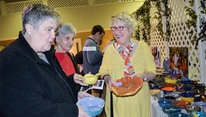 Carol Amos chooses bowls with with Cindy Hinton and Rachel Lee. Participants who supported the luncheon were able to choose one of the handmade bowls to take home.
