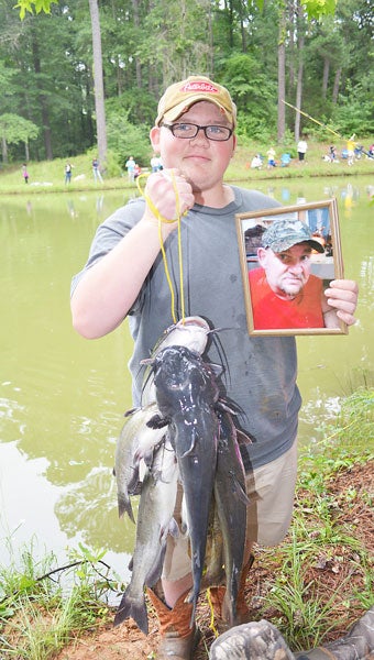 Denver Thomas and his dad, Edward, were regular fishing partners at Kids Fishing Day. Edward Thomas died in January but his son is keeping his memory alive. He placed his dad’s picture in an empty chair at Kids Fishing Day Saturday.