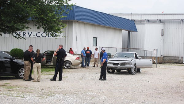 Troy Police Officers interview bystanders during their investigation of a domestic violence incident that led to gunshots at a Troy cold storage warehouse facility late Wednesday afternoon.