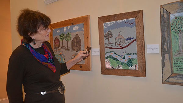 Messenger photo/Jaine Treadwell Wiley White of the Johnson Center for the Arts reviews some of the local artwork on sale at the center’s holiday pop-up shop.