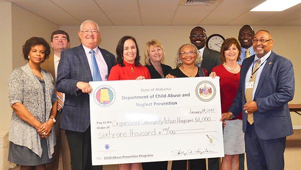 Troy OCAP received $61,000 from the State of Alabama Department of Child Abuse and Neglect Prevention on Wednesday in support of its Fatherhood Program. Pictured from left, are Sylvia Kenney Davis, Troy Mayor Jason A. Reeves, State Rep. Alan Booth, Tracy Plummer, Kim Livingston, Essie B. Thomas, Greg Lee, Mike Makau and Timothy Kemp.
